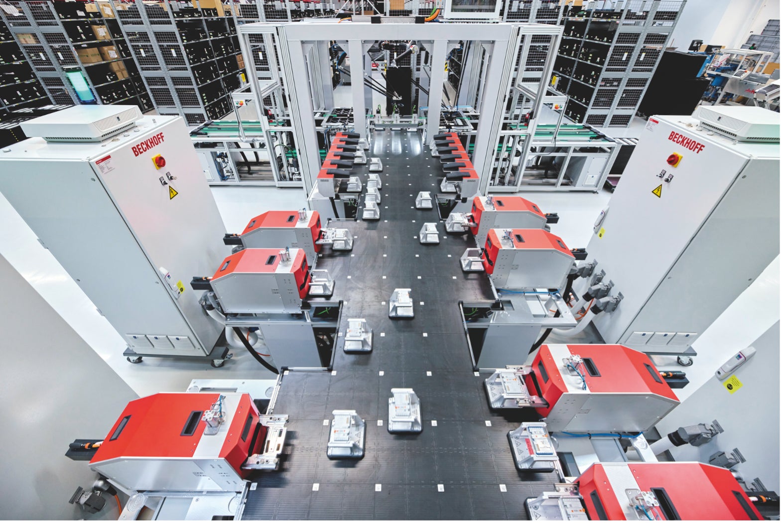 ベッコフドイツ本社の生産現場で稼働するXPlanar。 計100枚のXPlanarのタイル上を浮遊する  33台のマグネットプレートが生産工程を終えた様々なIOターミナルをそれぞれ個別の検査装置  に運び、自動検査を行っている。